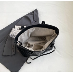 Close-up of the woven black tote bag interior showing grey lining and large capacity