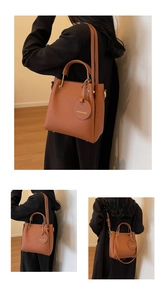 Detail of caramel lychee grain leather tote with gold hardware and circular bag charm