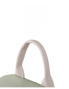 Detail of pink faux leather handle and green nylon fabric with precise stitching