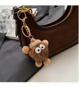 Détail d'un porte-clés en peluche pour sac avec fourrure brune et fermoir doré