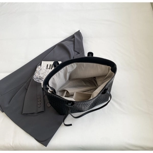 Detail view of woven leather tote bag interior with spacious compartment and lining