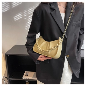Detail view of a beige cloud bag featuring soft pleated leather and stylish chain straps