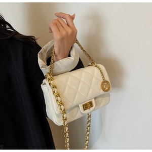 Detailed view of white quilted shoulder bag featuring gold chain and GAHREL metal tag