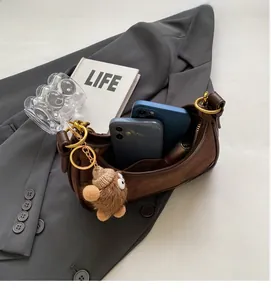 Détail de la capacité intérieure du sac croissant en daim marron avec breloque d'ours