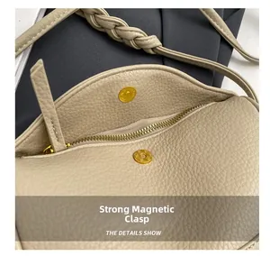 Detail of beige leather dumpling bag showing strong magnetic clasp and metal zipper