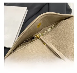 Close-up of smooth metal zipper and magnetic closure on beige lychee leather bag