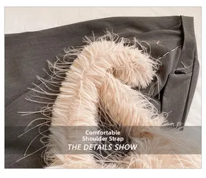 Detail showing the fluffy pink plush shoulder strap texture on a grey crossbody bag
