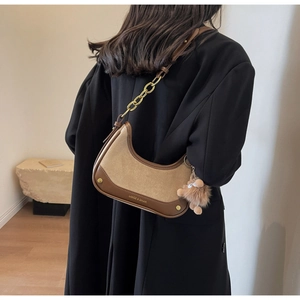 Détail du sac croissant avec textures en daim et pendentif ours mignon