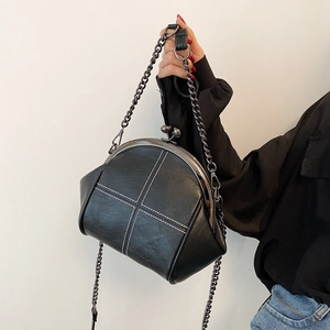 Minimalist shell-shaped crossbody bag with white stitching and metal chain strap