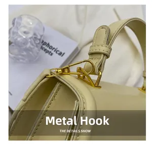 Close-up of elegant gold hardware hook and premium cream leather on a stylish handbag