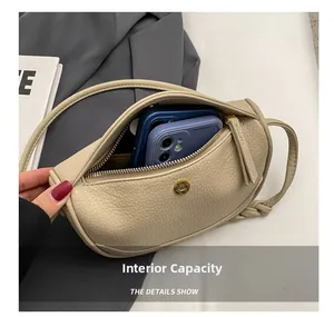 Detail of the cream leather dumpling bag interior showing spacious dual phone compartments
