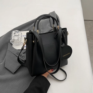 Modern black pebbled leather bucket bag with top handle and adjustable shoulder strap