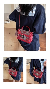 Detail of red embroidered handbag with cloud patterns and horse charm accessory