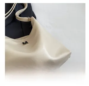 Macro detail of cream lychee texture PU leather shoulder bag with metallic M logo