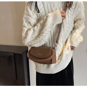Sac bandoulière en cuir marron grainé porté par un mannequin pour illustrer la taille
