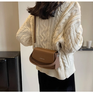 Détail d'un sac bandoulière en cuir marron avec motif litchi et logo Fashion & Bags