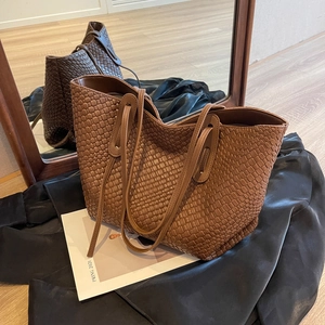 Vintage brown woven oversized tote bag with long straps shown in front of mirror