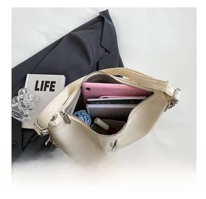 Spacious interior of off-white crescent bag with M logo fitting a tablet and notebook