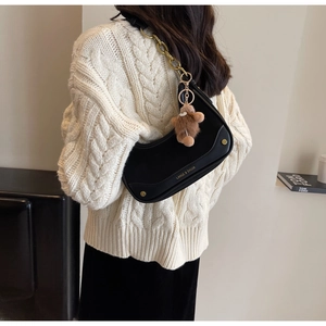 Détail du sac hobo noir en croissant avec chaîne dorée et charm d'ours en peluche doux