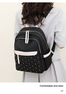 Detail of black nylon backpack featuring diamond quilted patterns and gold rivet studs