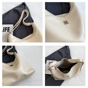 Detail view of cream white faux leather bag showing litchi texture and silver M logo