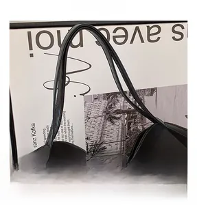 Close-up of black tote bag durable handle straps with smooth stitching detail