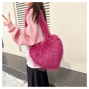 Detailed texture of vibrant pink heart-shaped faux fur tote bag with long fluffy hair