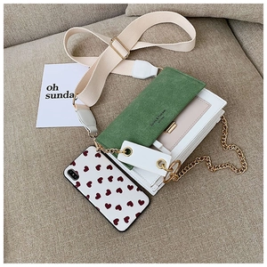 Détail du sac carré en daim vert avec chaîne dorée et logo Sunrita Fashion