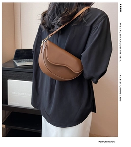Detailed back view of a brown saddle shoulder bag featuring a sleek matte PU leather finish