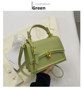 Detailed shot of green matte leather handbag with gold twist lock and fine strap