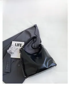Detail of black Hobo shoulder bag with chain strap and metallic M logo accent