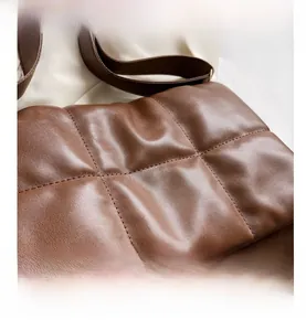 Détail du sac en cuir PU marron matelassé avec surpiqûres carrées et texture rembourrée