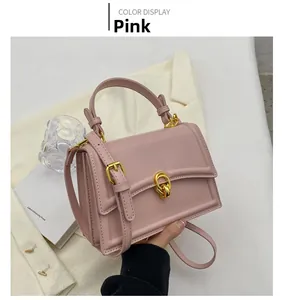 Pink matte leather crossbody bag featuring gold twist lock and elegant top handle