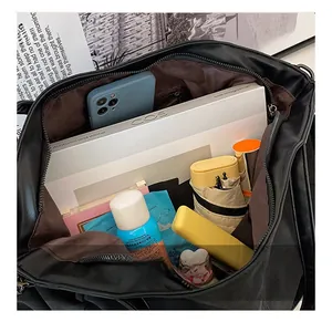 Top view of large black tote bag showing spacious interior with various daily essentials