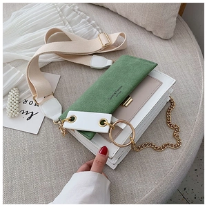 Détail du sac à bandoulière en daim vert avec corps crème et double chaîne dorée