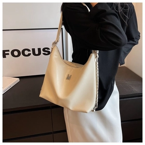 Detail of cream white hobo bag featuring silver M logo and metallic chain shoulder strap