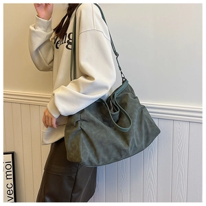 Detailed view of dark green oversized tote bag texture and reinforced stitching on straps