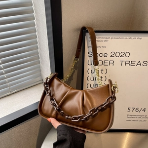 Brown ruched cloud bag with bold chain strap and sleek minimalist leather finish