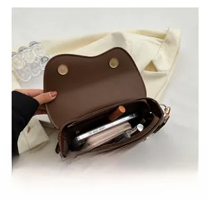 Interior view of brown leather crossbody bag showing capacity for phone and wallet