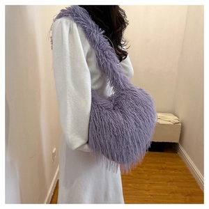 Detail view of the large purple fuzzy faux fur shoulder bag worn by a model