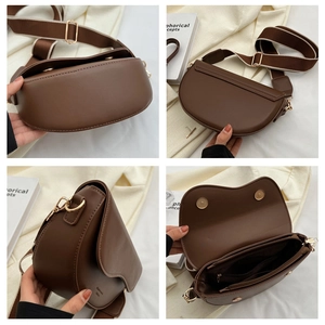Detail view showing brown saddle bag structure with striped strap and internal zip pockets