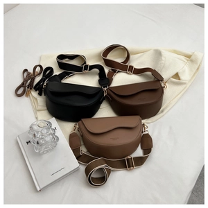 Three half-moon crossbody bags in black and brown with adjustable wide fabric straps