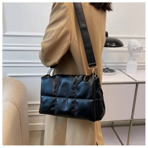 Détail du sac bandoulière matelassé noir avec des ferrures en métal doré luxueuses