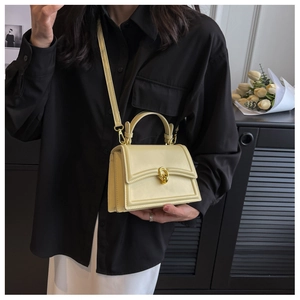 Chic cream leather crossbody bag with elegant golden interlocking buckle on flap closure
