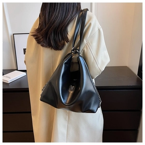 Detailed view of black faux leather shoulder bag with silver metal M logo and chain