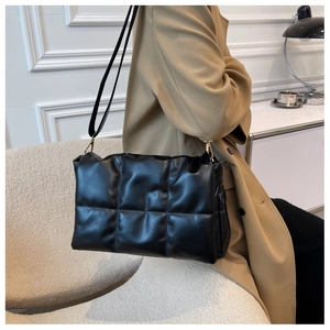 Gros plan sur un sac à bandoulière matelassé noir avec des finitions en métal doré chic