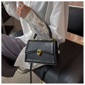 Detail of elegant black matte leather bag with golden ring buckle and adjustable strap