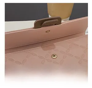 Détail du fermoir en métal doré de qualité sur un portefeuille rose en cuir gaufré