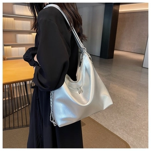 Detail of silver metallic tote bag with M-logo charm and chain-link leather shoulder strap