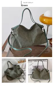 Detail of dark green leather tote bag with sturdy handles and adjustable shoulder strap